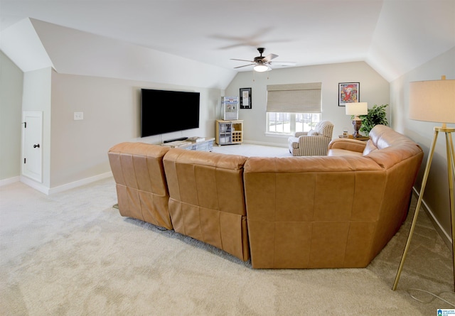 living room featuring vaulted ceiling, ceiling fan, baseboards, and light colored carpet