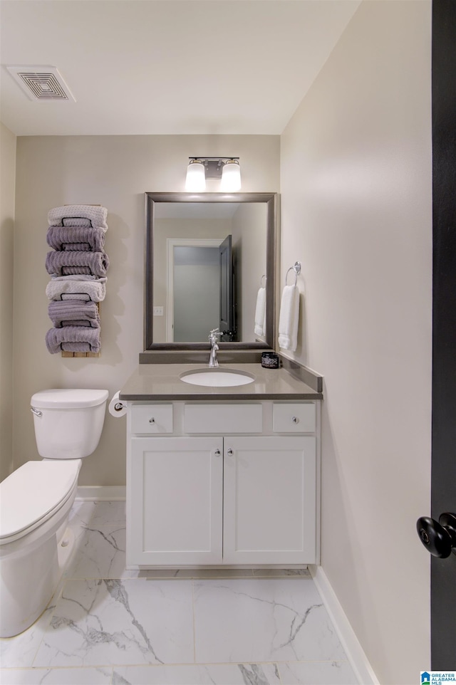 bathroom featuring toilet, vanity, visible vents, baseboards, and marble finish floor