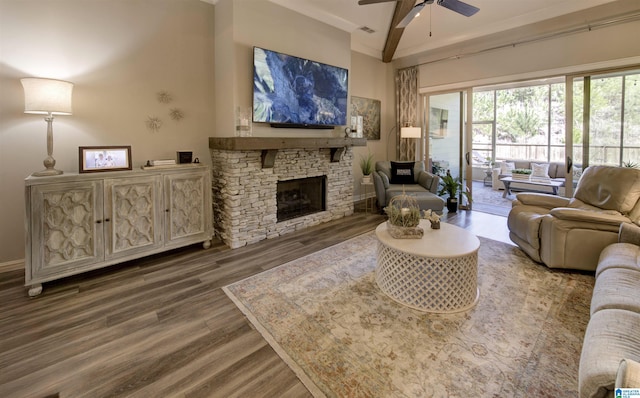 living area featuring a fireplace, wood finished floors, visible vents, a towering ceiling, and a ceiling fan