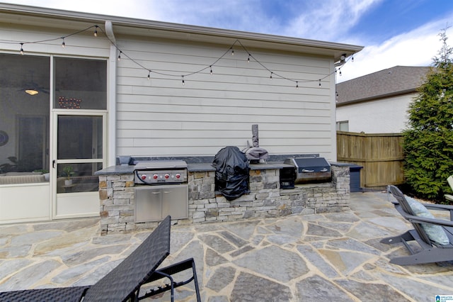 view of patio / terrace featuring area for grilling, fence, and a grill