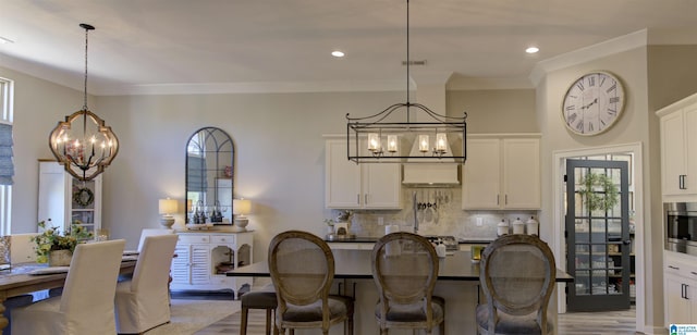 dining area with recessed lighting, crown molding, and an inviting chandelier