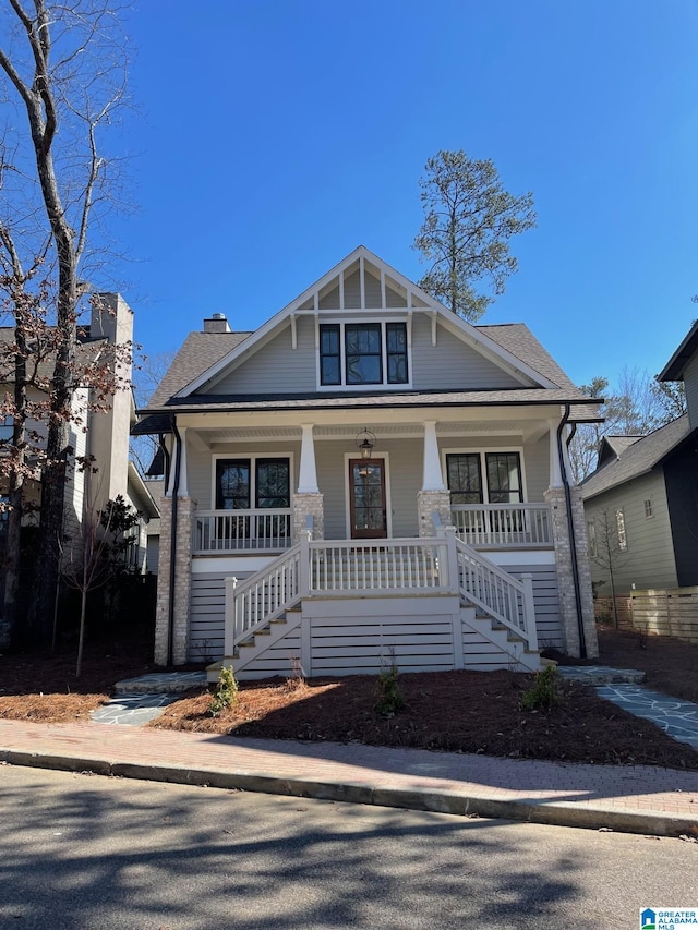 view of front of home with covered porch and a shingled roof