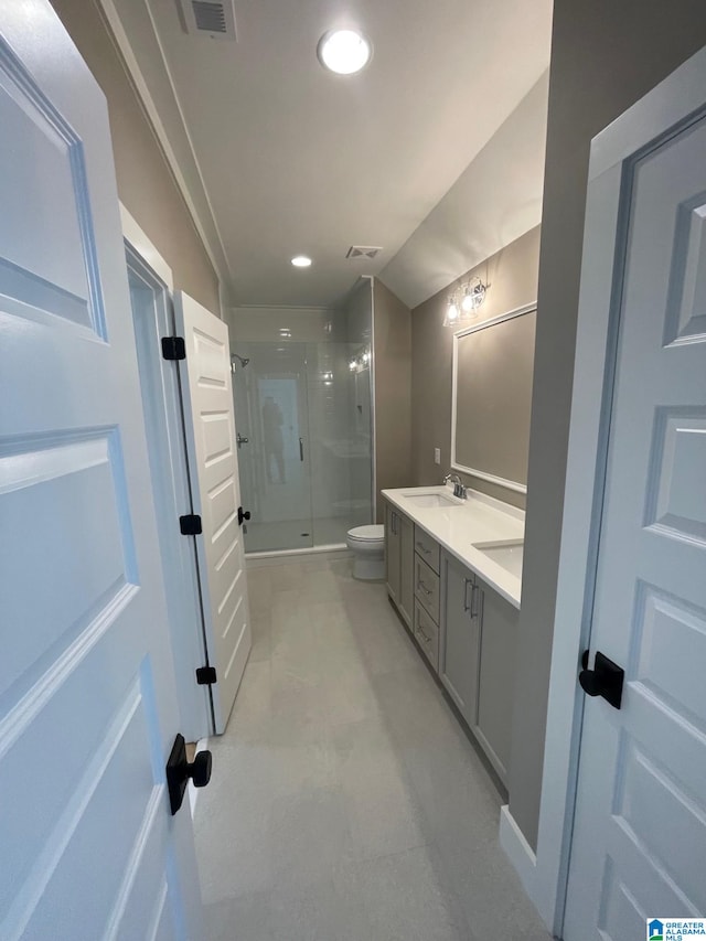 bathroom with double vanity, recessed lighting, toilet, a stall shower, and a sink