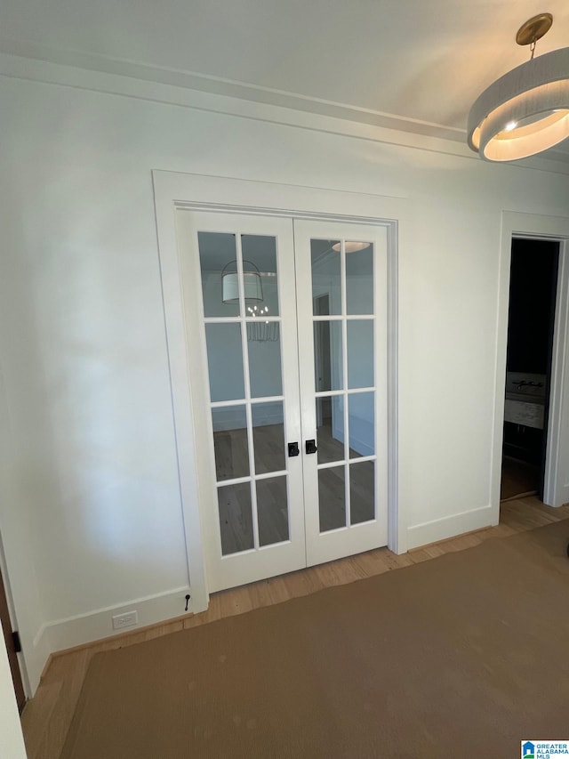 entryway with baseboards, wood finished floors, and french doors