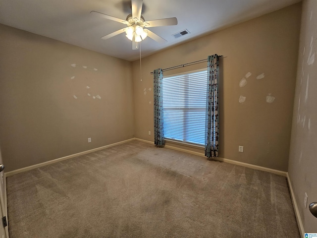 carpeted spare room featuring visible vents, ceiling fan, and baseboards