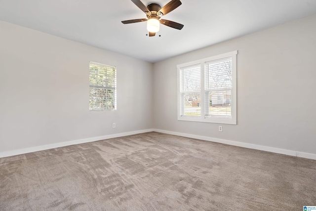 spare room with baseboards, ceiling fan, and carpet flooring