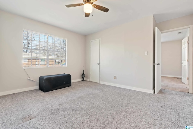 unfurnished bedroom featuring visible vents, baseboards, a ceiling fan, and carpet flooring