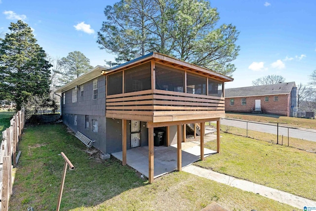 exterior space featuring a sunroom, a fenced backyard, a yard, a patio area, and driveway