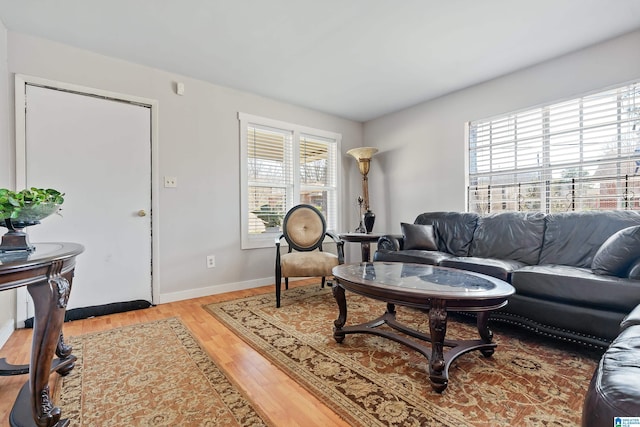 living room with light wood finished floors, baseboards, and a wealth of natural light