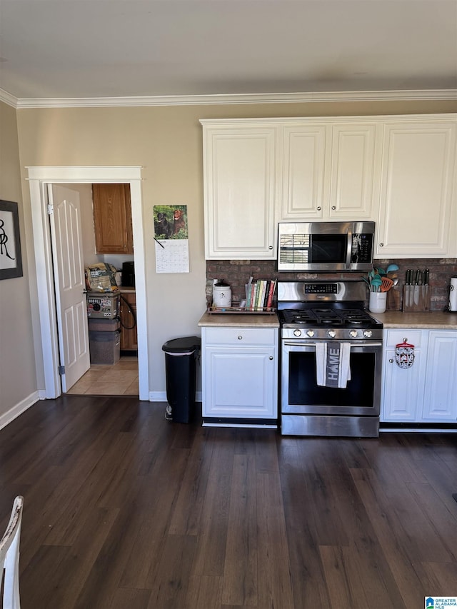 kitchen with stainless steel appliances, tasteful backsplash, dark wood finished floors, and white cabinetry