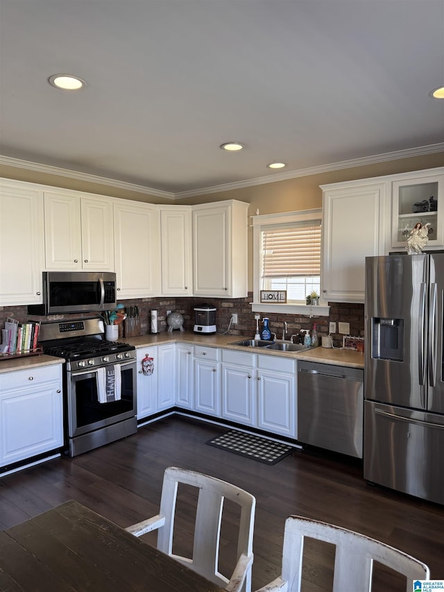 kitchen with white cabinets, appliances with stainless steel finishes, backsplash, and a sink