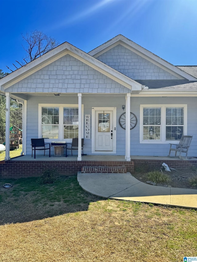 view of front of property with covered porch and a front lawn