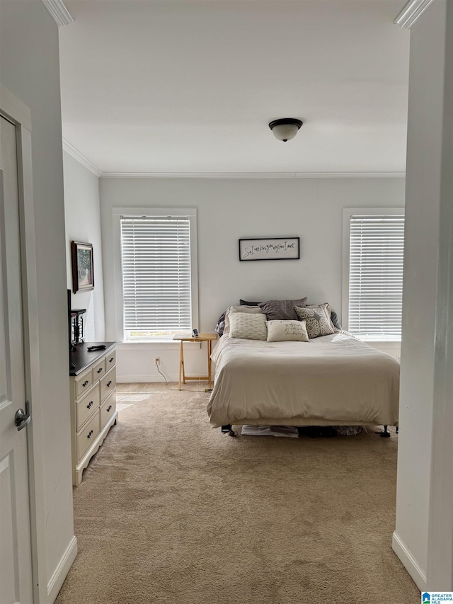 bedroom featuring ornamental molding, light colored carpet, and baseboards