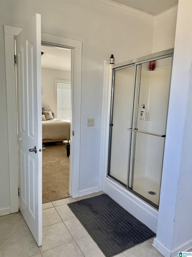 full bathroom with a stall shower, baseboards, ensuite bathroom, tile patterned flooring, and crown molding