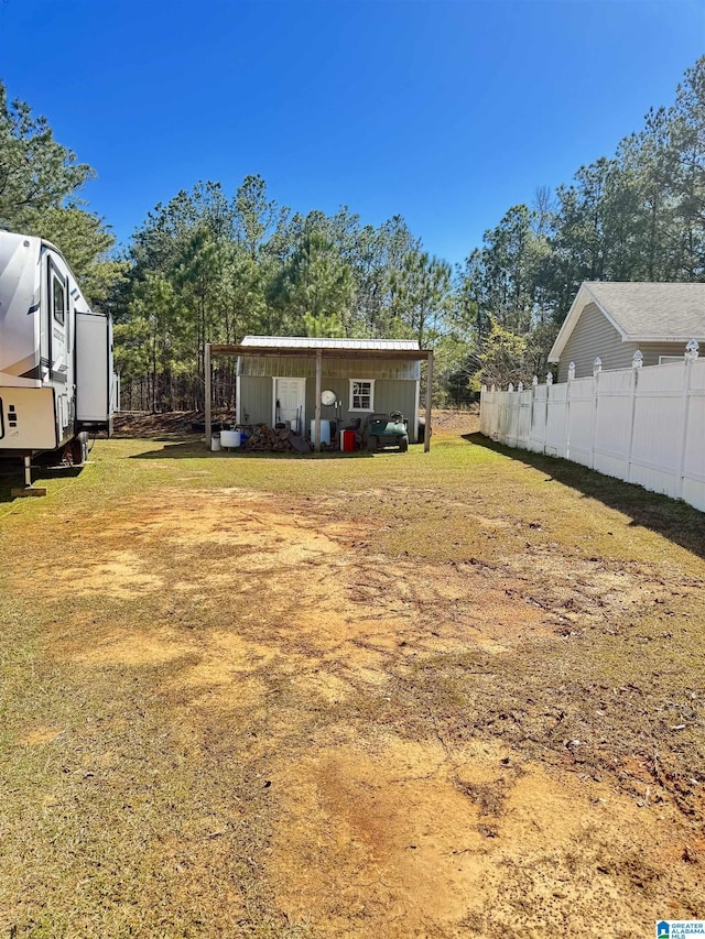 view of yard featuring an outdoor structure and fence