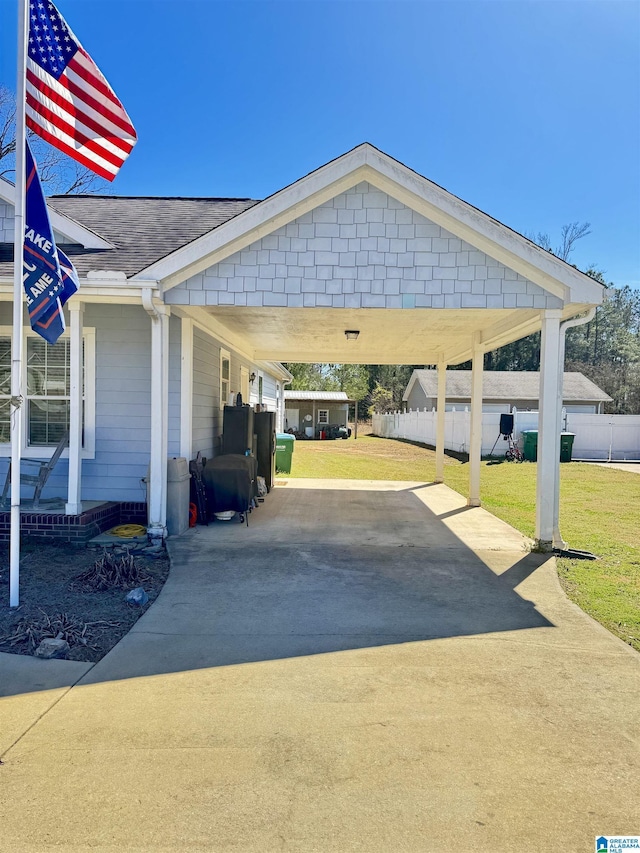 view of car parking with concrete driveway and fence