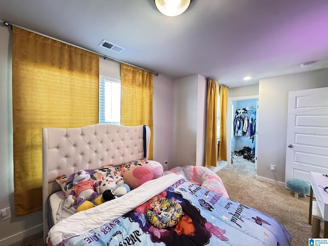 bedroom featuring carpet, visible vents, a spacious closet, and baseboards