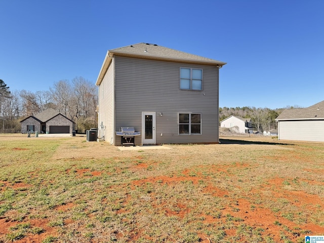 back of house featuring a yard and central air condition unit