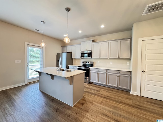 212 Buckhorn Cir, Weaver, AL 36277 - kitchen featuring appliances with stainless steel finishes, a kitchen island with sink, dark wood finished floors, a kitchen bar, and recessed lighting