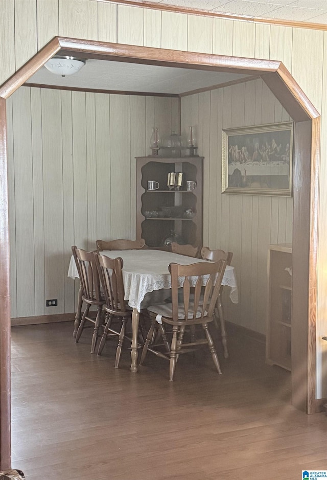 dining room with wood walls and wood finished floors