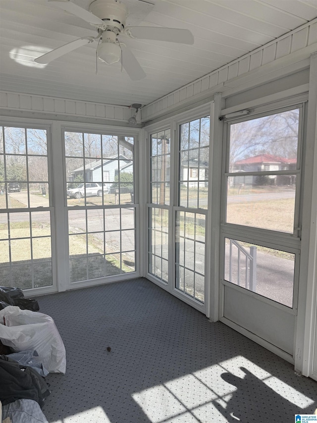 unfurnished sunroom featuring a wealth of natural light and ceiling fan