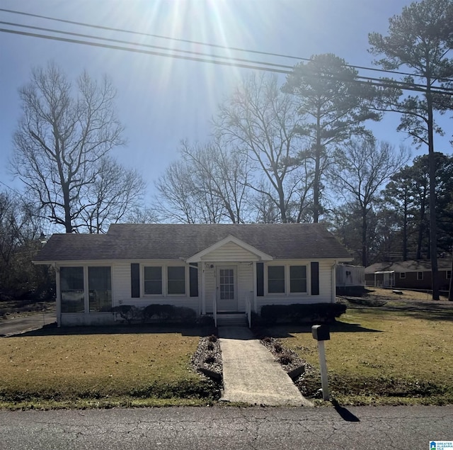 view of front facade featuring a front yard and a sunroom