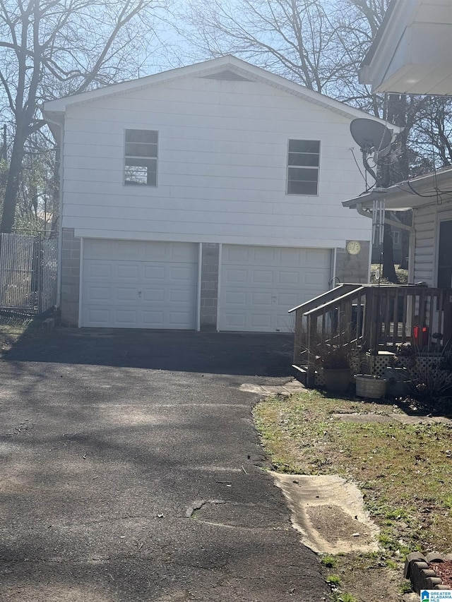 view of side of home with aphalt driveway and a garage