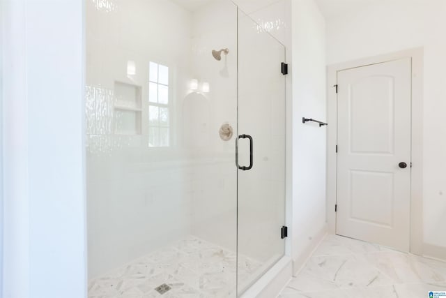 full bath with marble finish floor and a shower stall