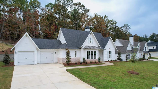 view of front of property with a garage, driveway, a shingled roof, and a front yard