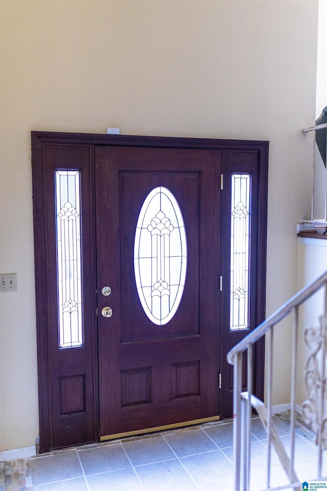 tiled foyer entrance with plenty of natural light and stairs
