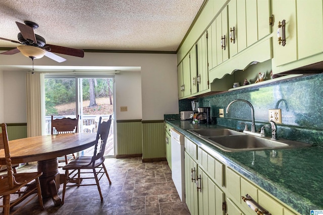 kitchen featuring wainscoting, a sink, a textured ceiling, white dishwasher, and green cabinetry