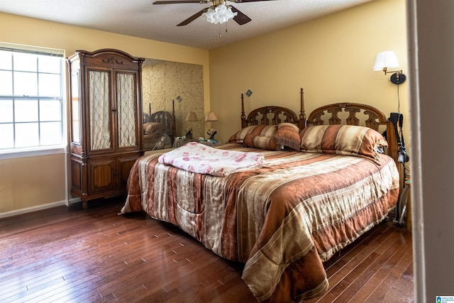 bedroom featuring a textured ceiling, dark wood finished floors, a ceiling fan, and baseboards