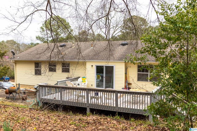 back of property with a shingled roof and a wooden deck