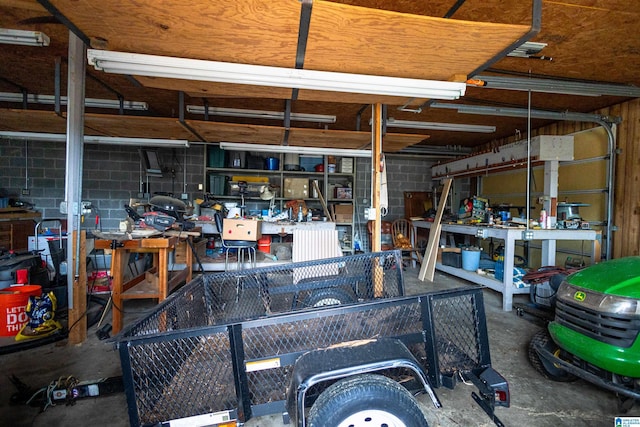 garage with concrete block wall and a workshop area