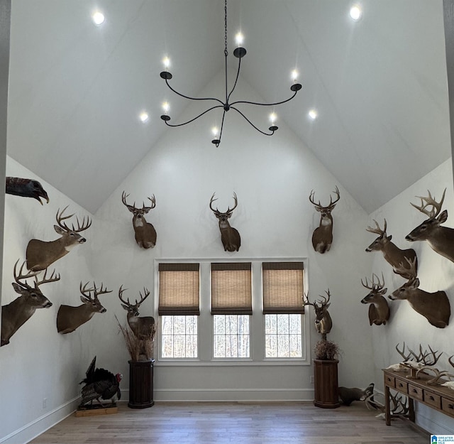 interior details with a chandelier, wood finished floors, and baseboards