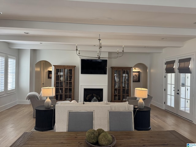 living room with arched walkways, a fireplace, and baseboards