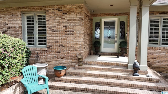 doorway to property featuring brick siding