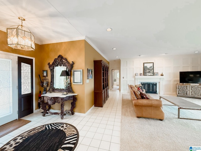 foyer entrance with a glass covered fireplace, crown molding, and light tile patterned floors