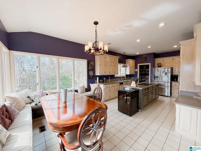 kitchen featuring cream cabinets, stainless steel appliances, a chandelier, a sink, and light tile patterned flooring