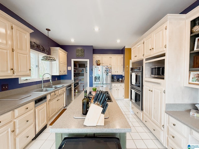 kitchen featuring appliances with stainless steel finishes, light tile patterned flooring, a sink, and a kitchen island