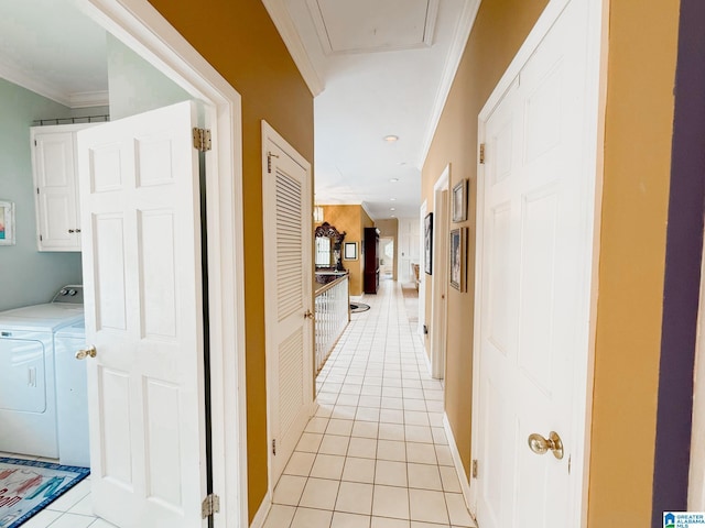 hallway featuring light tile patterned floors, washing machine and dryer, and ornamental molding