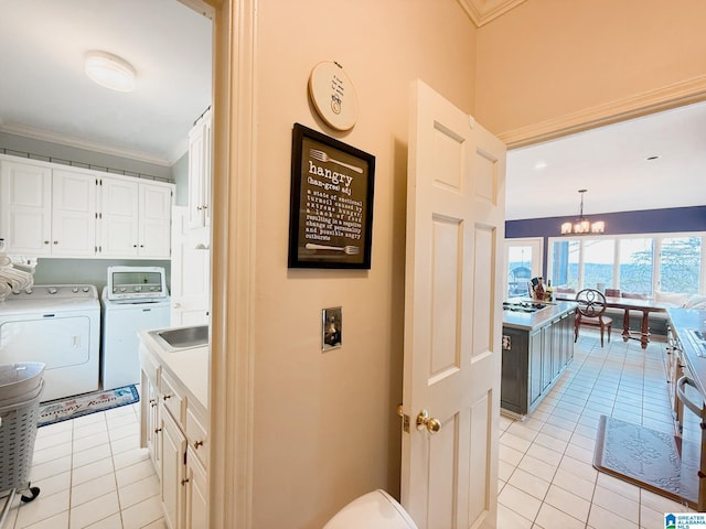 washroom featuring light tile patterned floors, cabinet space, an inviting chandelier, ornamental molding, and independent washer and dryer