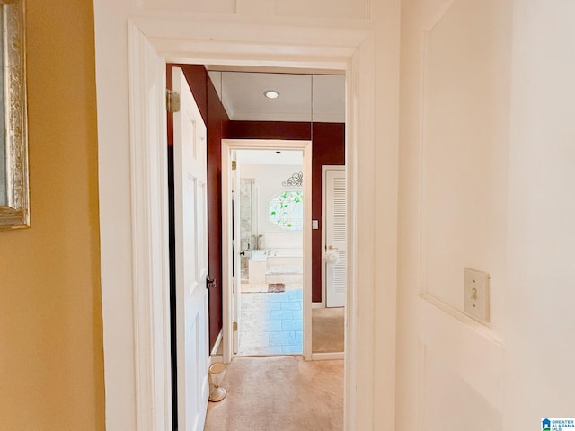 hallway featuring light colored carpet