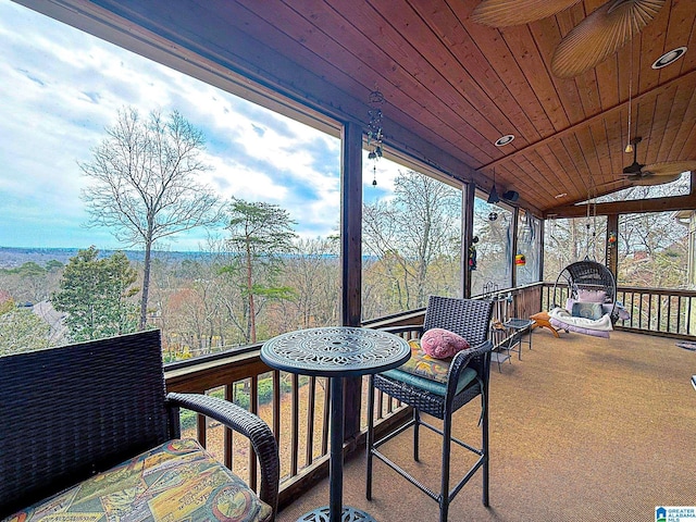 sunroom with a ceiling fan, lofted ceiling, and wooden ceiling