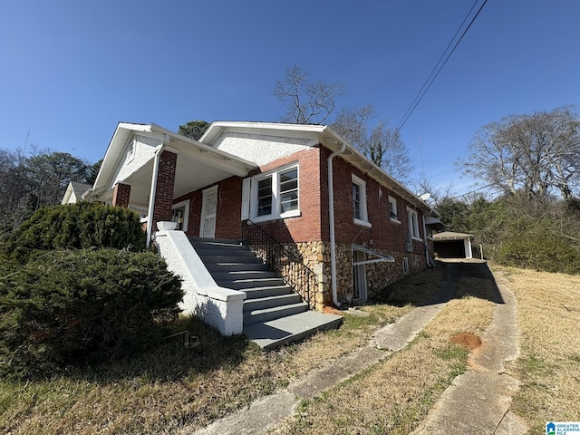 view of home's exterior with stairway and brick siding