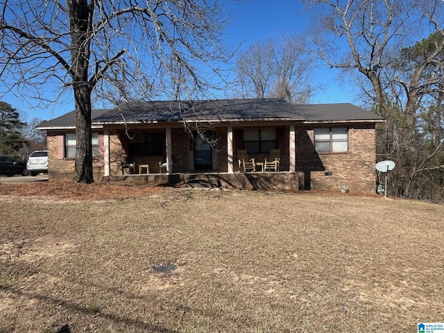 view of front of house with brick siding, crawl space, and covered porch