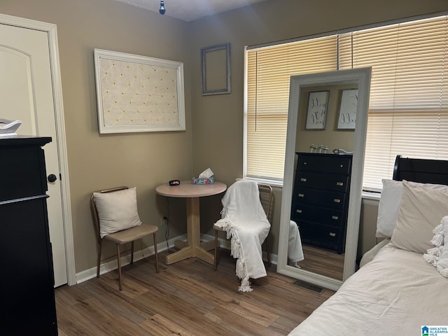 bedroom with visible vents, baseboards, and wood finished floors