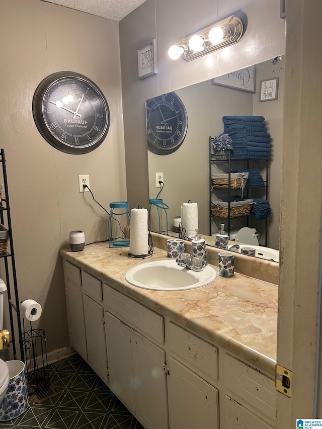 bathroom featuring a textured ceiling and vanity