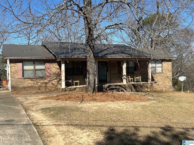 single story home featuring brick siding, covered porch, and metal roof