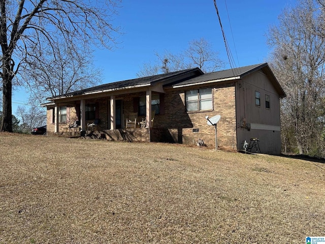 view of front of property featuring a porch, brick siding, and crawl space